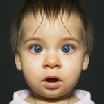 gespiegeltes Babyportrait mit großen neugierigen Augen